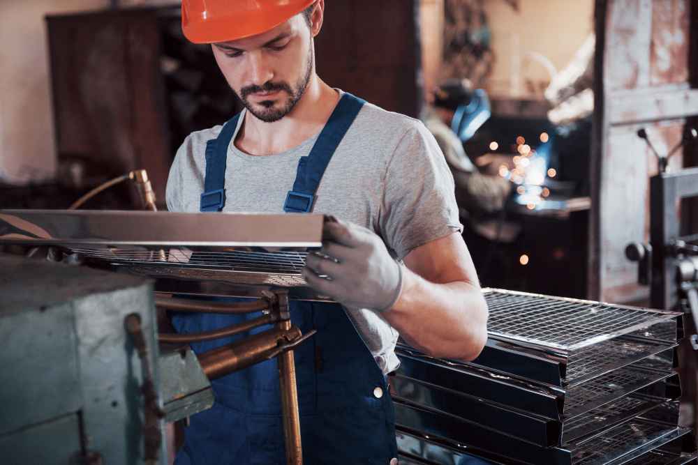How to prevent failures in industrial products before they occur Operator inspecting metal parts during quality control in an industrial manufacturing process