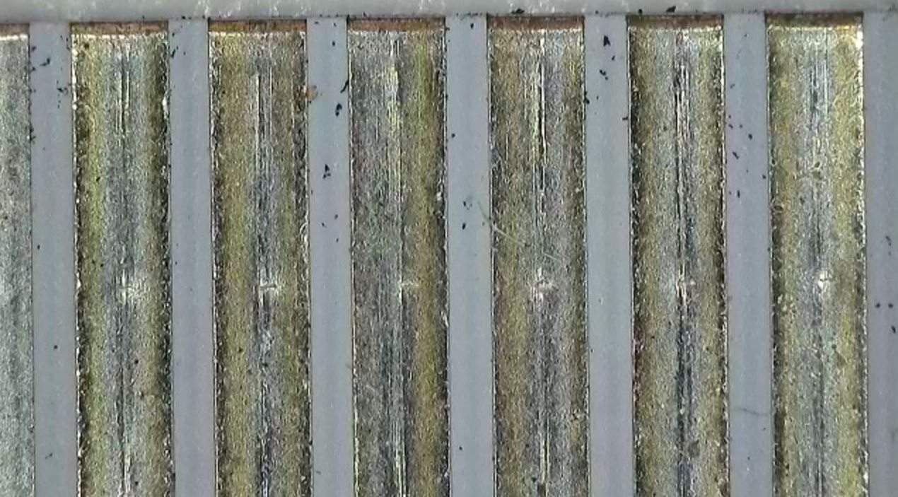 Imagen microscópica de residuos desconocidos detectados en un componente eléctrico durante un análisis de fallos