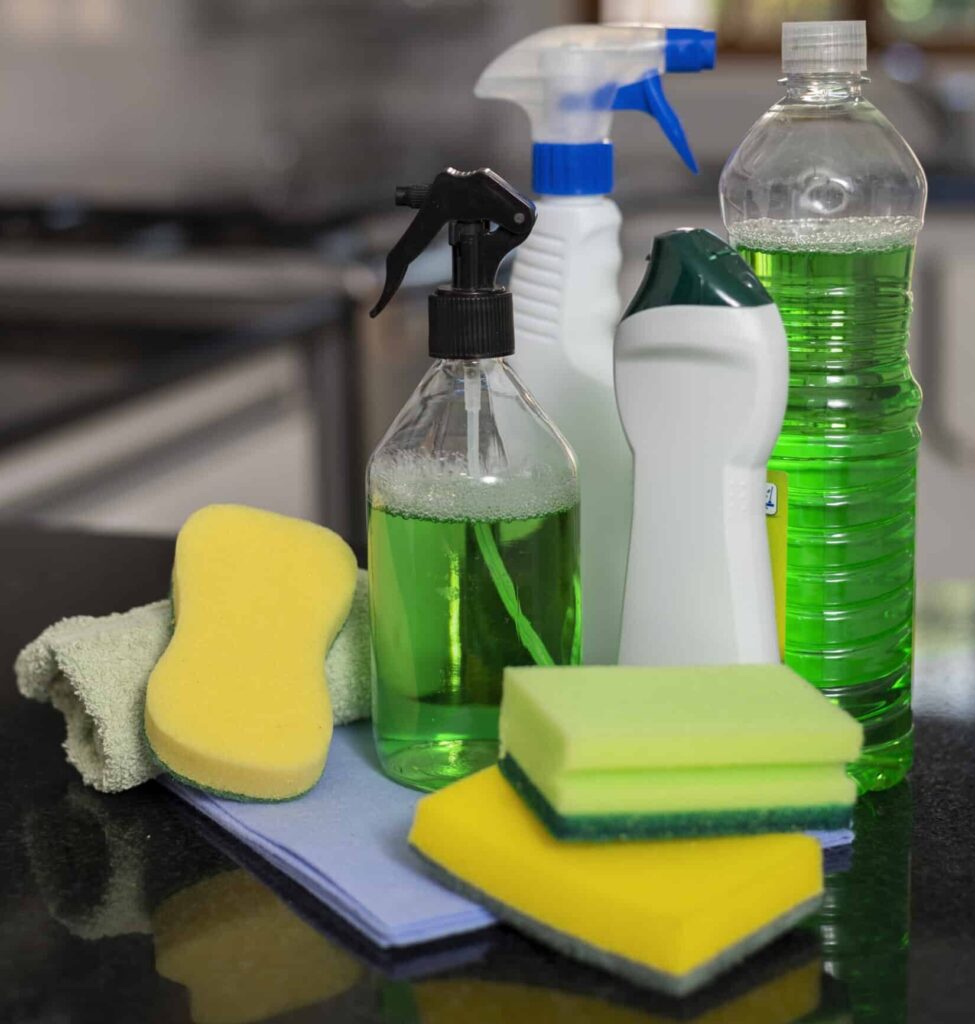 Productos de limpieza como detergentes líquidos y esponjas utilizados para evaluar el efecto de detergentes en superficies y la compatibilidad química con materiales